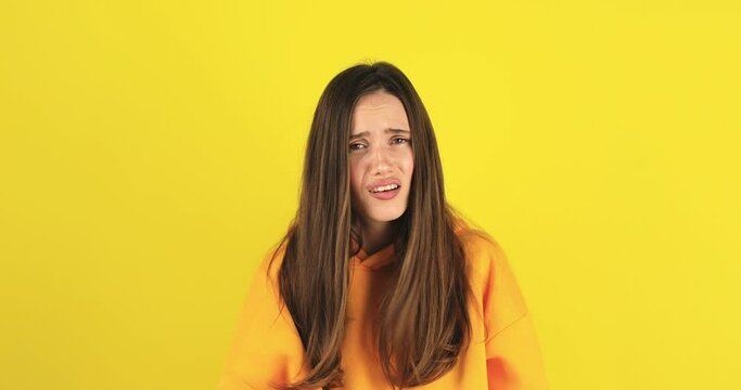 Are you crazy, out of mind. Confused woman pointing at camera and showing stupid gesture, blaming asking some idiot for insane plan, bullying. Brunette girl isolated on yellow background look angry.