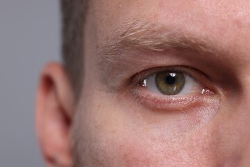 Fototapeta premium Closeup view of man with beautiful eyes on grey background