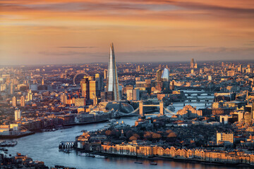 Panoramic sunrise view of the London skyline with Tower Bridge and river Thames in soft sunlight, England