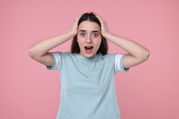 Portrait of surprised woman on pink background