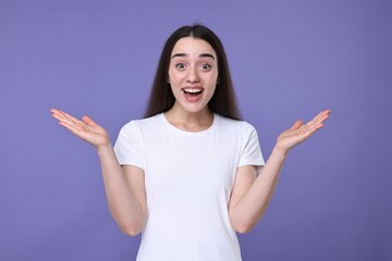 Portrait of happy surprised woman on violet background