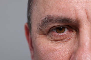 Closeup view of man with beautiful eyes on grey background