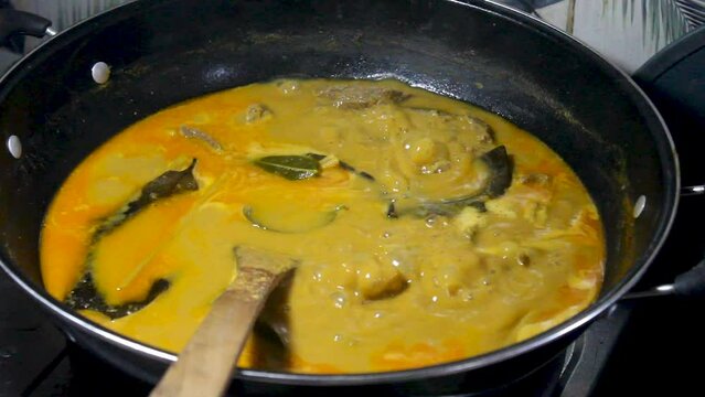 boiling, cooking the spice "rendang" with a cauldron. Traditional Indonesian food made from beef with coconut milk seasoning.