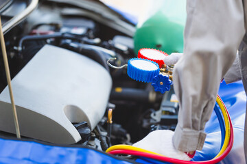 Fototapeta premium Technician check car air conditioning system refrigerant recharge, Repairman holding monitor tool to check and fixed car air conditioner system, Car Air Conditioning Repair.