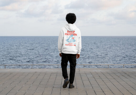 Mockup of man wearing customizable hoodie by ocean
