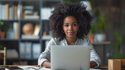 Shot of beautiful afro business woman working with laptop sitting in the office. - obrazy, fototapety, plakaty