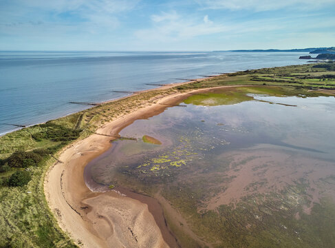 Aerial view of beach and dunes at Dawlish Warren, guarding the mouth of the River Exe, looking south along the coast towards the town of Dawlish, Devon, England
