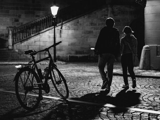 bicycle and couple on the old town street at night