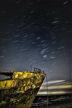 Star trails above the derelict trawler Vita Nova, from the Cumbrian Coast, Furness Peninsula, Cumbria, England