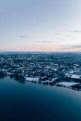 Aerial View of a City during sunset reflecting in a calm river