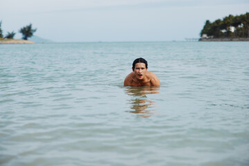 Smiling Asian Man Enjoying a Tropical Swim in the Blue Ocean