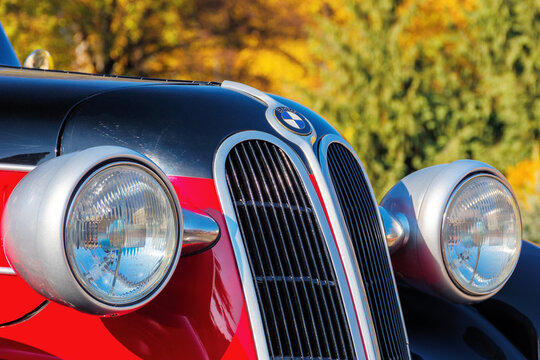 uzhgorod, ukraine - 31 oct 2021: front close-up of a red bmw 321 oldtimer with black hood. sunny outdoor in autumn park