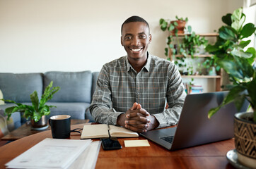 Smiling young African businessman working remotely from home