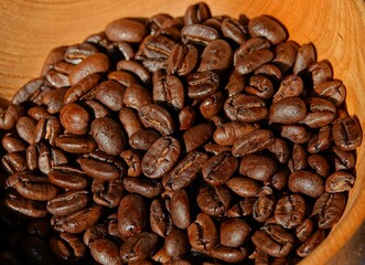 Des grains de café torréfiés à la lumière du soleil dans un bol en bois 