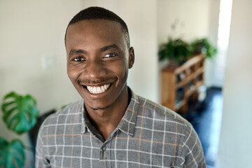 Smiling young African businessman standing at home during a break