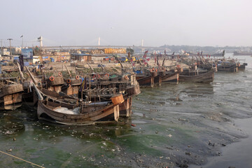 Fototapeta na wymiar As the Chaktai canal of Chittagong is filled, the boats get stuck during the low tide. Due to this, businessmen and passengers suffered