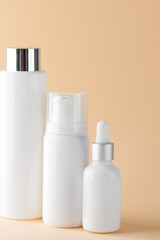 Jars with cosmetics for face and body care on a beige background.