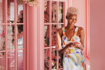 Smiling black woman texting on cellphone