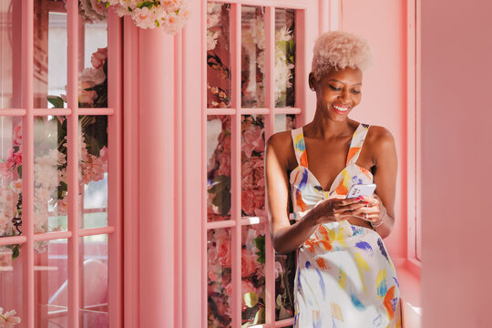 Smiling black woman texting on cellphone