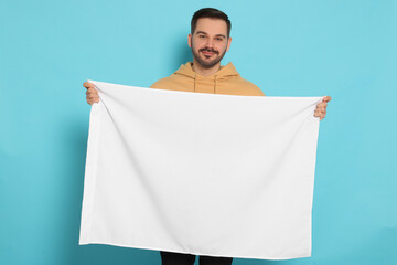 Man with blank white flag on light blue background. Mockup for design