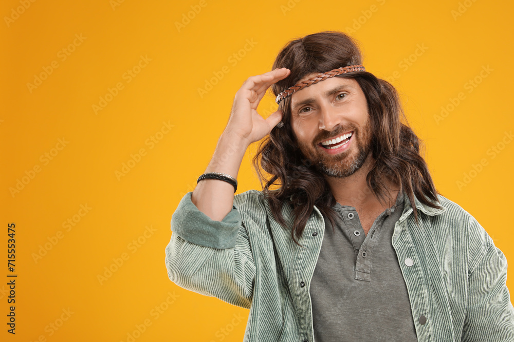 Poster Stylish hippie man on orange background, space for text