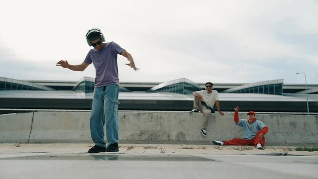 Group of asian break dancer perform street dance with multicultural friend support and moving hip hop music. Attractive handsome hipster practice b boy dance at street. Outdoor sport 2024. Sprightly.