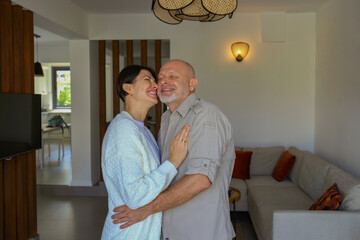 Portrait of affectionate adult couple hugging at home, expressing the love to each other. Close up,...