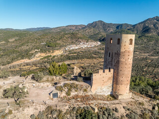 Aerial view of Almonecir Castle,  in the Sierra de Espadán above Vall de Almonacid, irrigated farmlands and an extensive olive groves with horseshoe shaped great tower partially restored