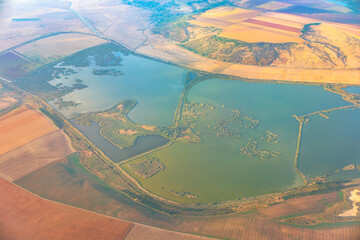 Aerial view of a lake in the middle of the fields. Swamp view from above