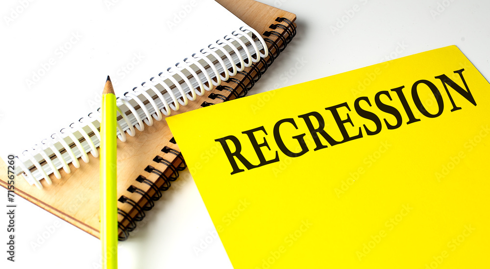 Poster regression text written on a yellow paper with notebook