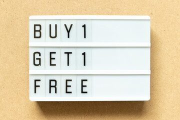 Lightbox with word buy 1 get 1 free on wood background