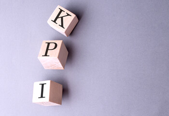 Word KPI on wooden block on the grey background