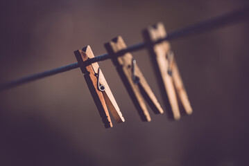 Three clothespins placed artistically on the wire. Minimalist image made in the garden