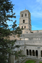 Obraz premium Cloister and tower of the Church of St Trophime, Saint Trophime cathedral, Arles, Provence, France. Pine tree in the foreground.