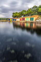 Fototapeta na wymiar Scenic view of colored boat shelters in south of France on rainy cast during winter near Saint Tropez