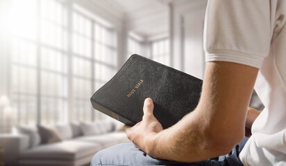 Human hands of prayer hold bible book