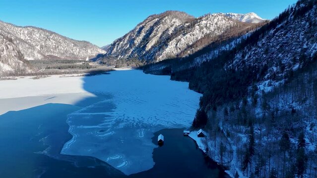 Drohnenflug &uuml;ber dem See in den Bergen in sch&ouml;ner Landschaft im Winter im Salzkammergut
