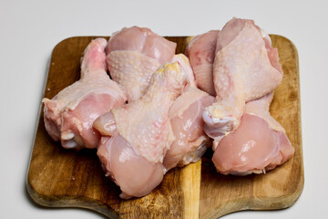 cleaned chicken legs on a wooden chopper.