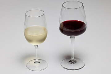 a glass of red wine and a glass of white wine on a table.