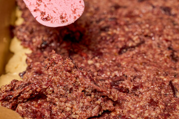 The hands of a woman preparing a traditional homemade dough cake in the kitchen.