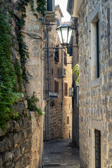 Fototapeta na wymiar Morning walk along winding narrow streets with ancient stone buildings in the old town of Kotor, Montenegro