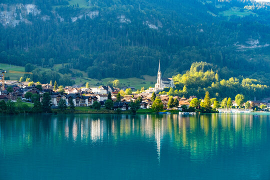 Swiss village Lungern with traditional houses, old church Alter Kirchturm along lovely emerald green lake Lungerersee, canton of Obwalden Switzerland