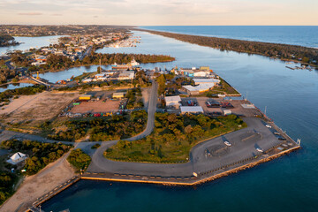 Aerial view of an industrial area and carpark on an island near a coastal community