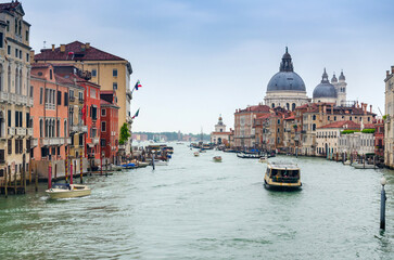 Grand canal in Venice, Italy, with divine Santa Maria della Salute church domintaing in the cityscape - obrazy, fototapety, plakaty