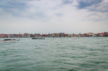 Part of a cityscape of Venice, Italy. with a boat in blue Adriatic sea