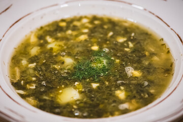 Green Ukrainian Borscht or sour soup, made with meat store Sorrel soup is made from water or broth,...