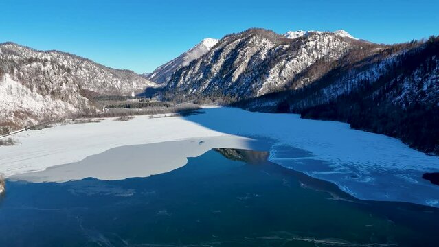 Drohnenflug &uuml;ber dem See in den Bergen in sch&ouml;ner Landschaft im Winter im Salzkammergut