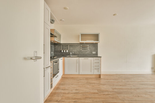 Modern kitchen interior with wooden floors and white cabinets