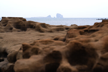 Fototapeta na wymiar rocks on the horizon above brown stone at the beach