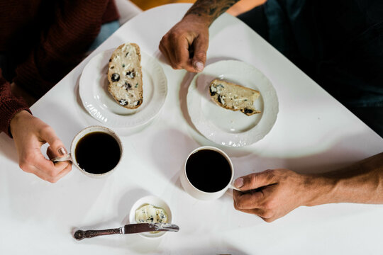 People sitting at a table drinking coffee and eating artisan bread